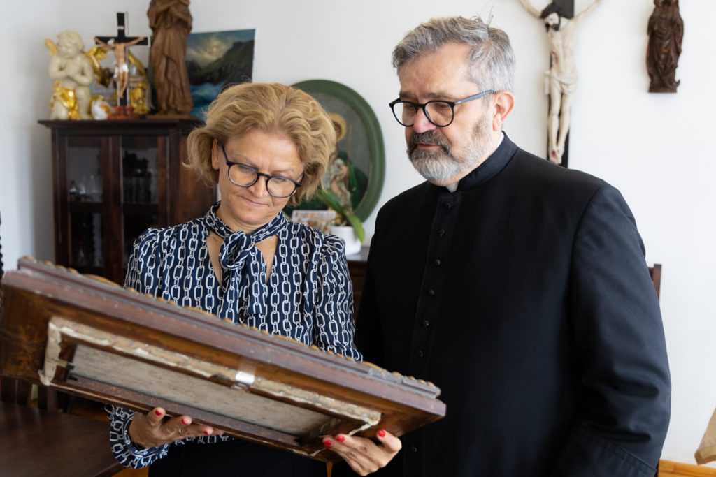 ksiądz kanonik Roman Krzyżaniak oraz dyrektor Sylwia Nowicka oglądają przekazywany obraz