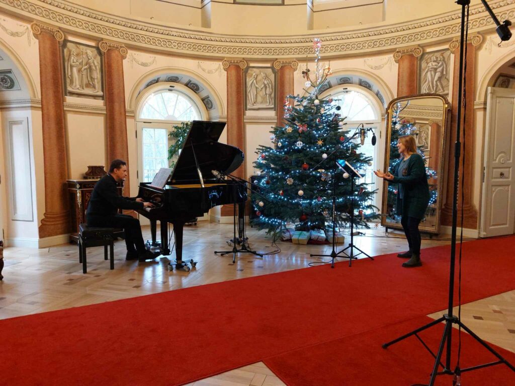 Zdjęcie przedstawia sopranistkę Darię Stachowicz oraz siedzącego przy fortepianie Roberta Adamczaka podczas nagrywania płyty.